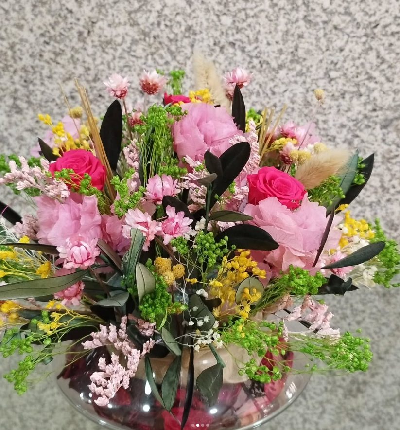 Ramo de rosas y flores rosas preparado en jarrón de cristal